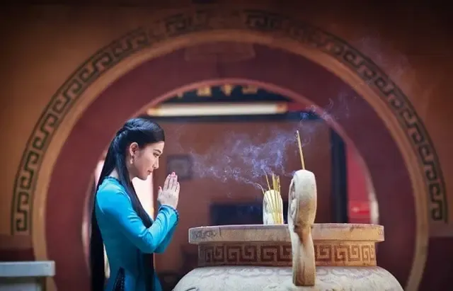 Người phụ nữ thắp hương và thực hiện văn khấn ông táo ngày rằm mùng một